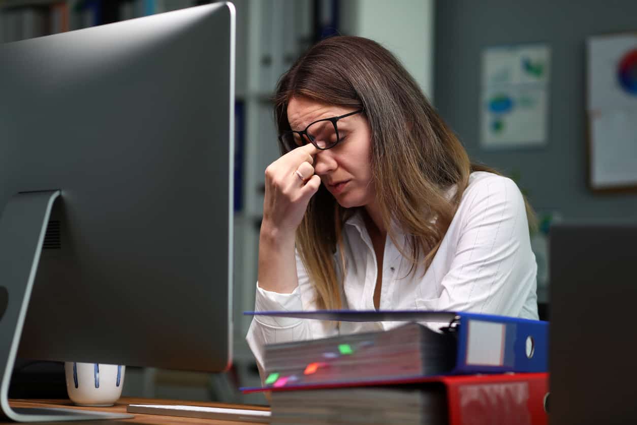 Een vrouw met slaapeloosheid achter haar computer - slaapproblemen