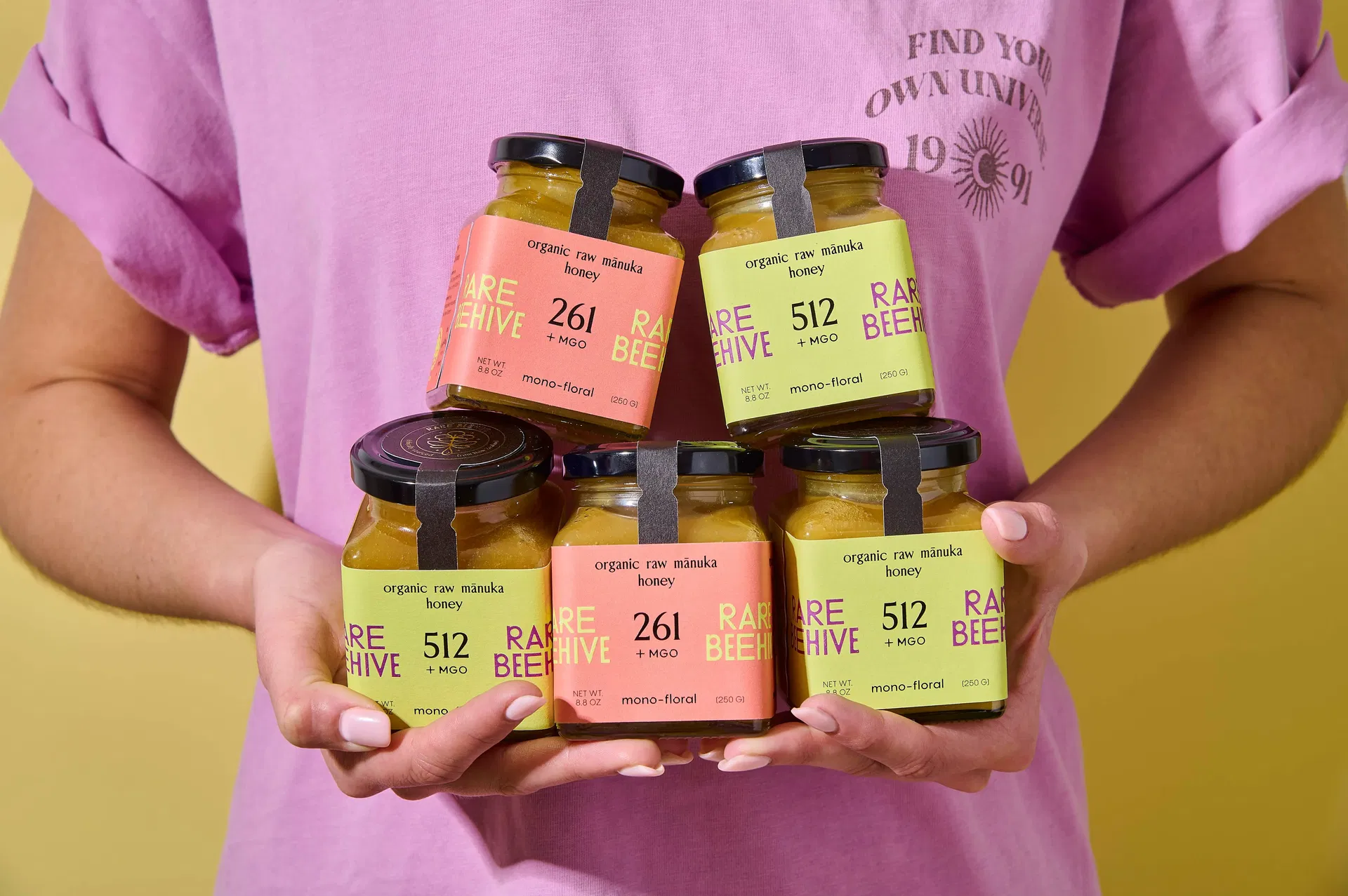 Person holding five jars of Rare Beehive Manuka Honey in 261+ MGO and 512+ MGO varieties