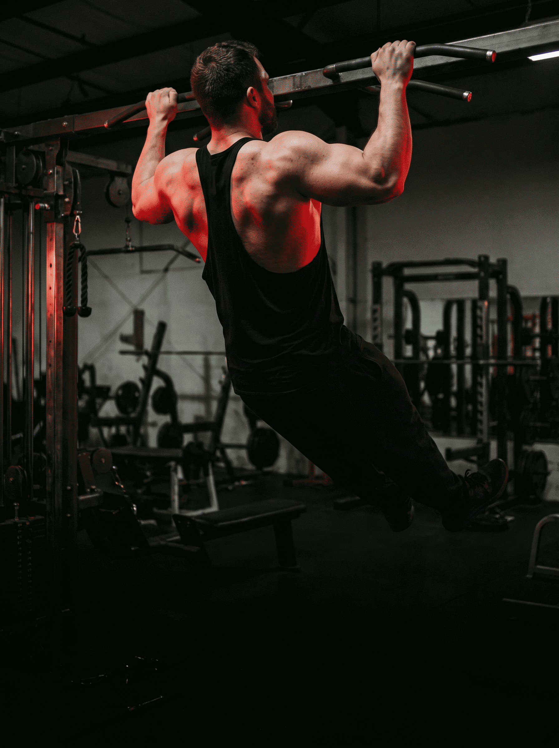 Bodybuilder struggling with a pull-up in the gym