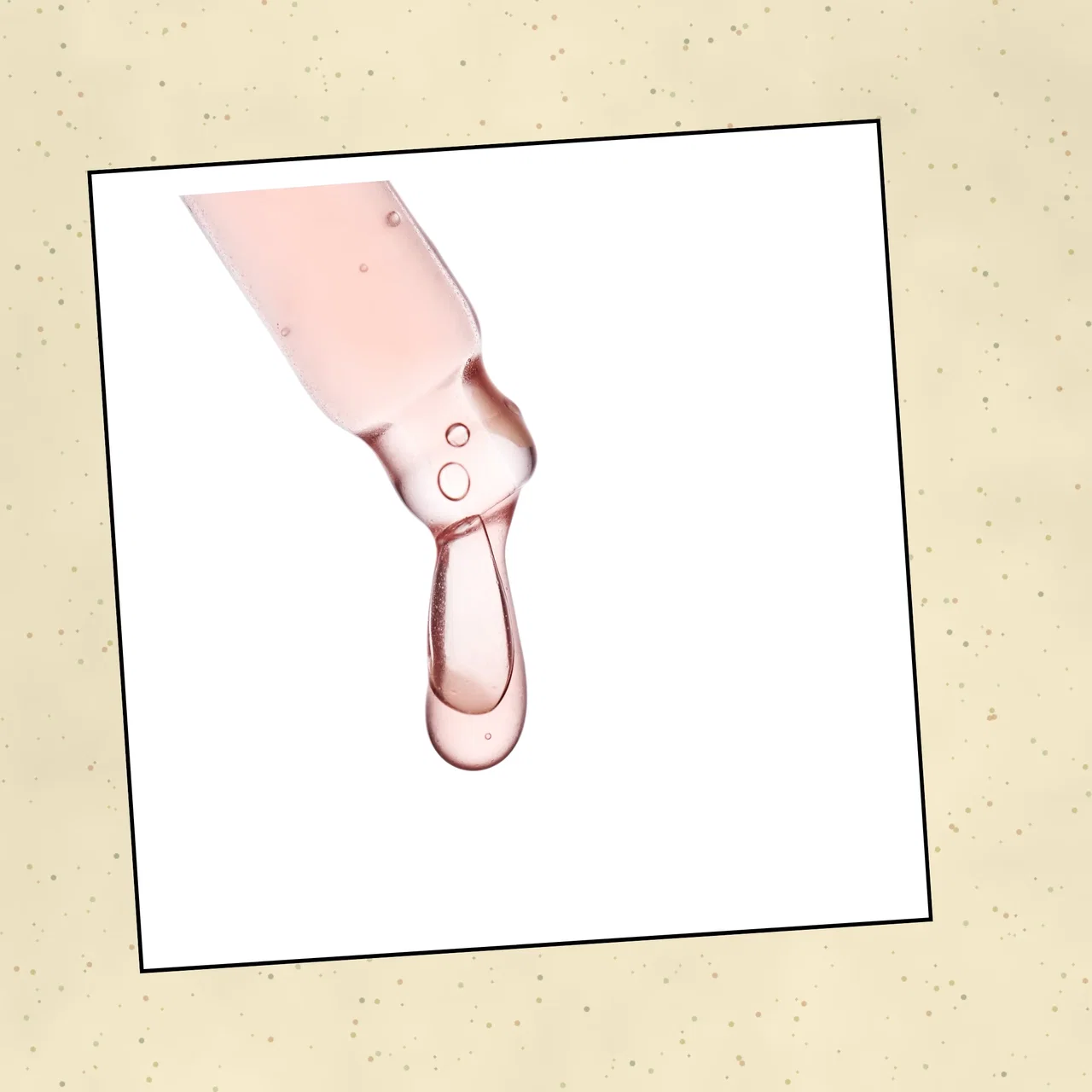 A dropper releasing a bead of pale pink oil against a white background representing squalane.