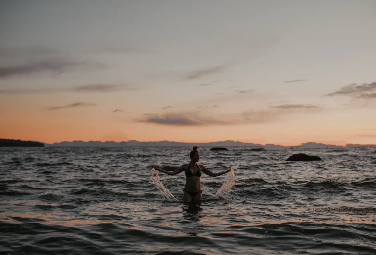 Samantha enjoying peaceful ocean sunset moment representing mindful wellness and self-care