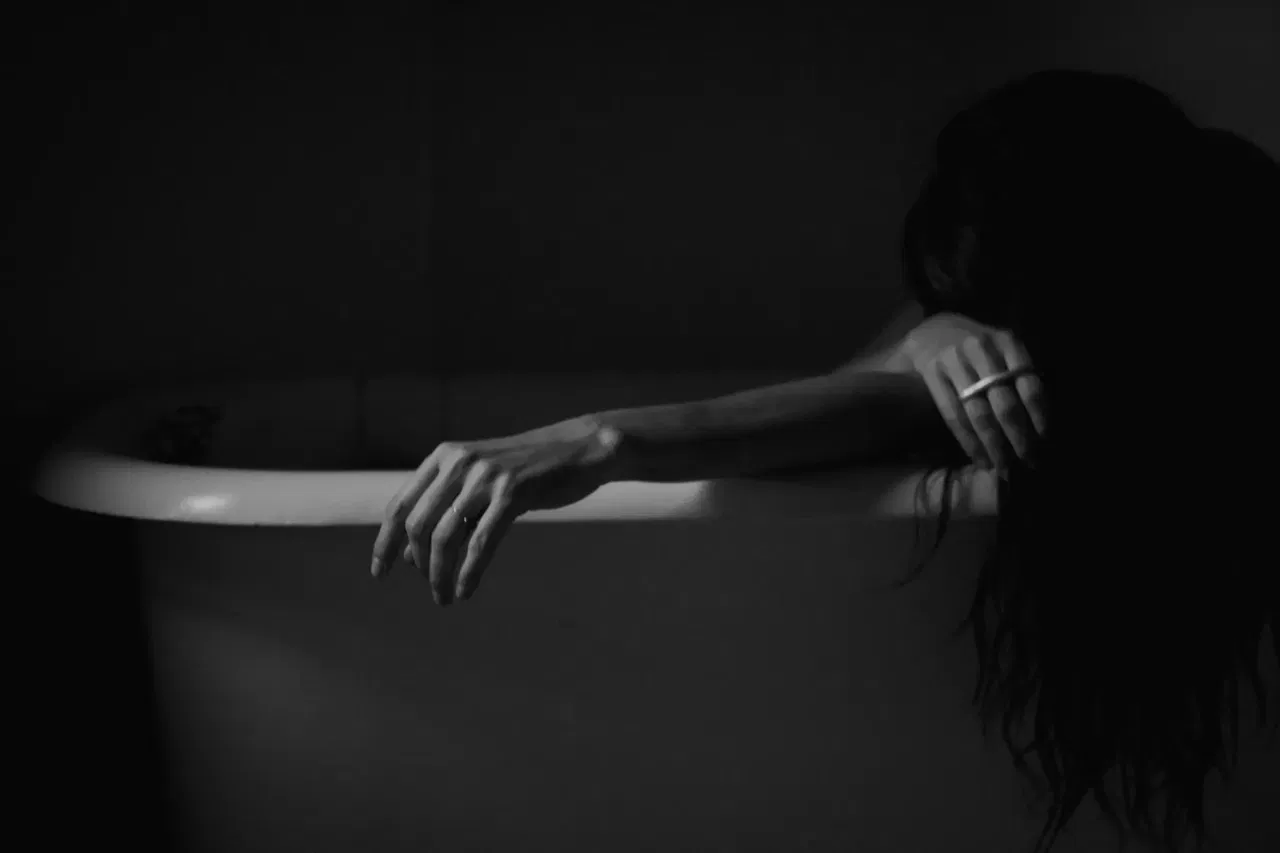 Artistic black and white portrait of Samantha embracing body confidence during menopause self-care moment