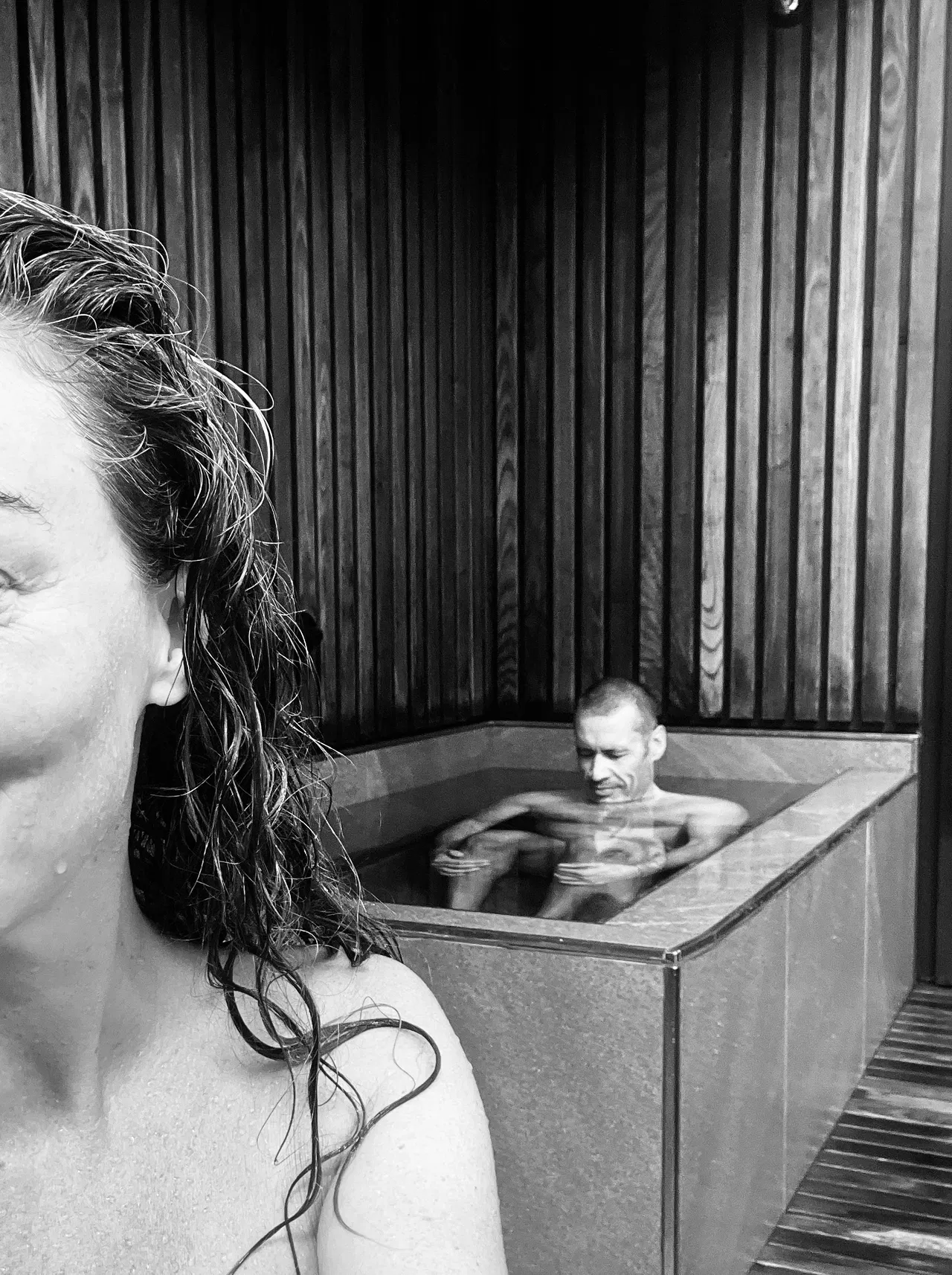 Crème co-founders Samantha Powell and Rafael Rolf Skala sharing an intimate moment in hot tub, black and white lifestyle photography