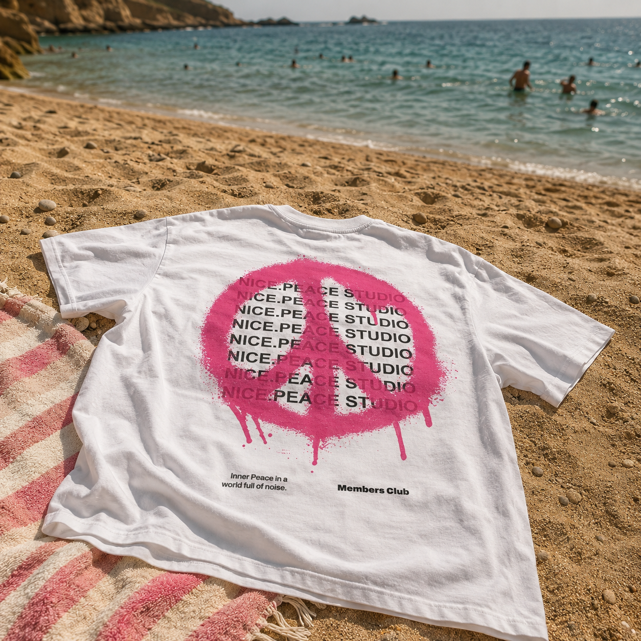 Nice.Peace Inner Peace T-Shirt White Pink – Oversized Streetwear Shirt in Weiß mit pinkem Peace-Zeichen Backprint im sommerlichen Beach-Look am Strand mit Meerblick