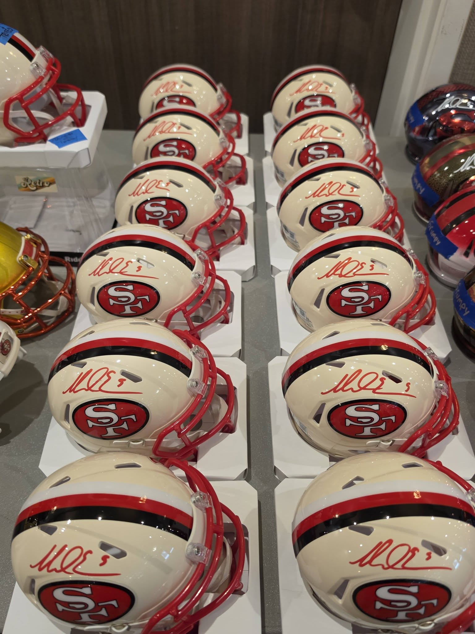 Row of signed mini football helmets on a shelf