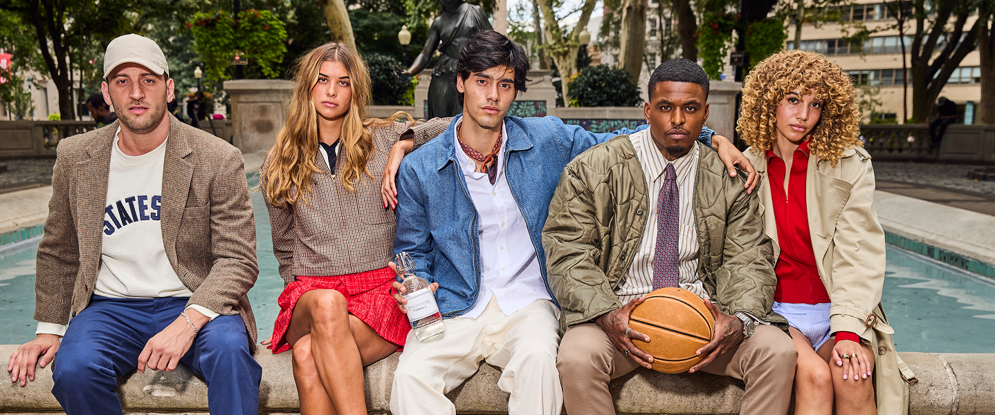 Five friends in classic American style sitting on a Philadelphia fountain ledge, one holding a bottle of Stateside Vodka
