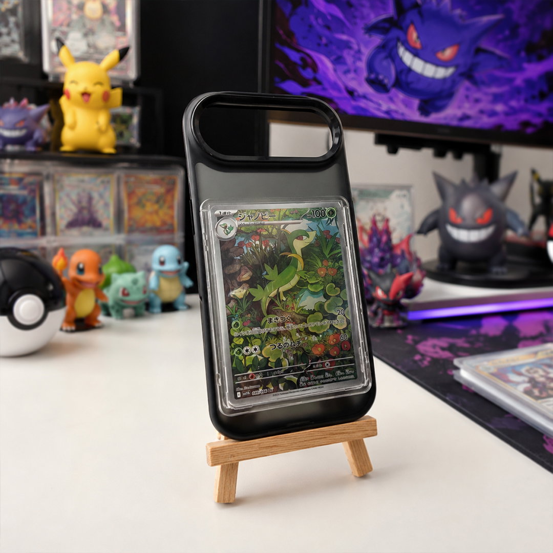 Black MagSafe case holding a graded card, standing on a wooden easel on a collector's desk