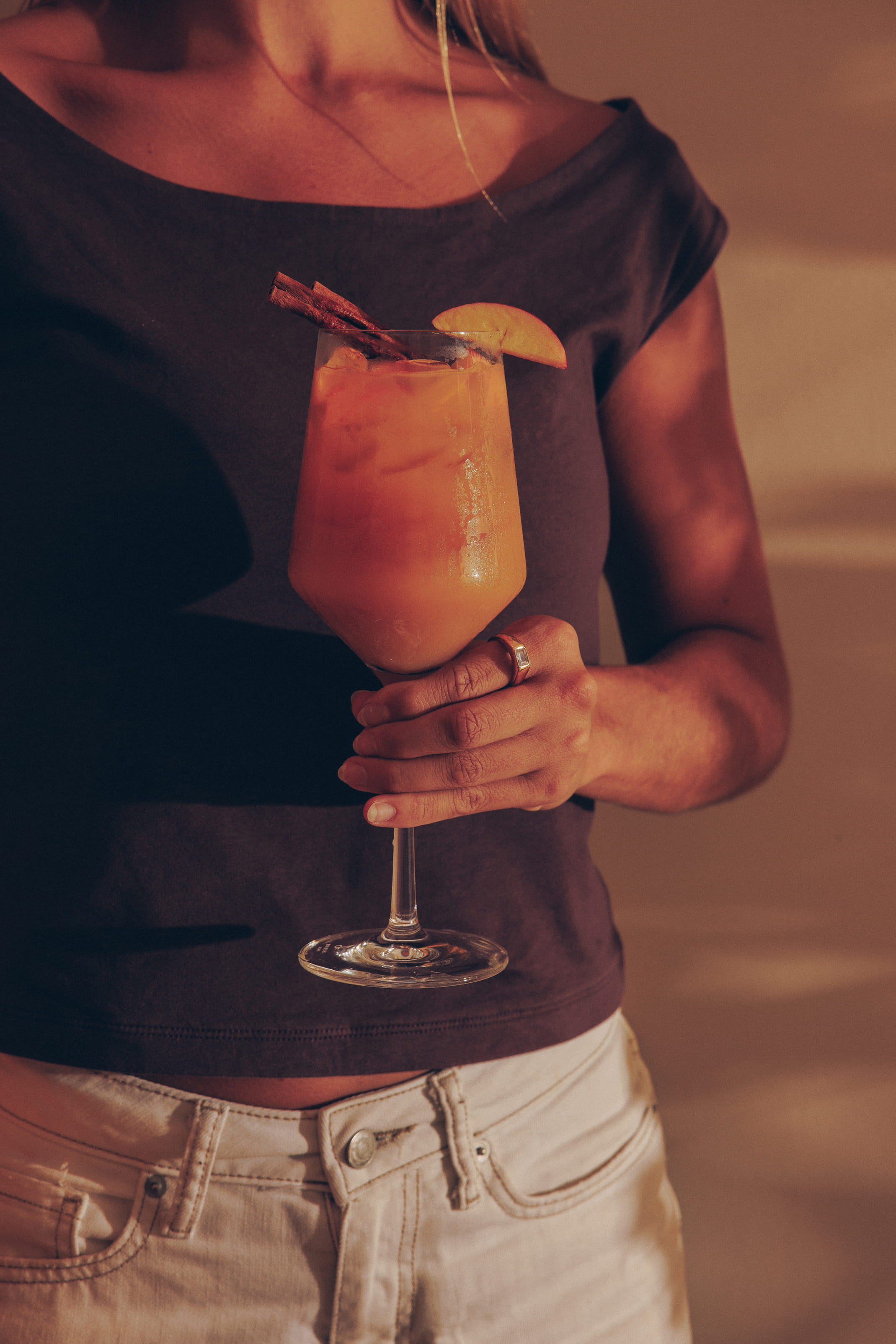 Woman relaxing at the edge of a pool with a citrus Kava Haven mocktail garnished with grapefruit