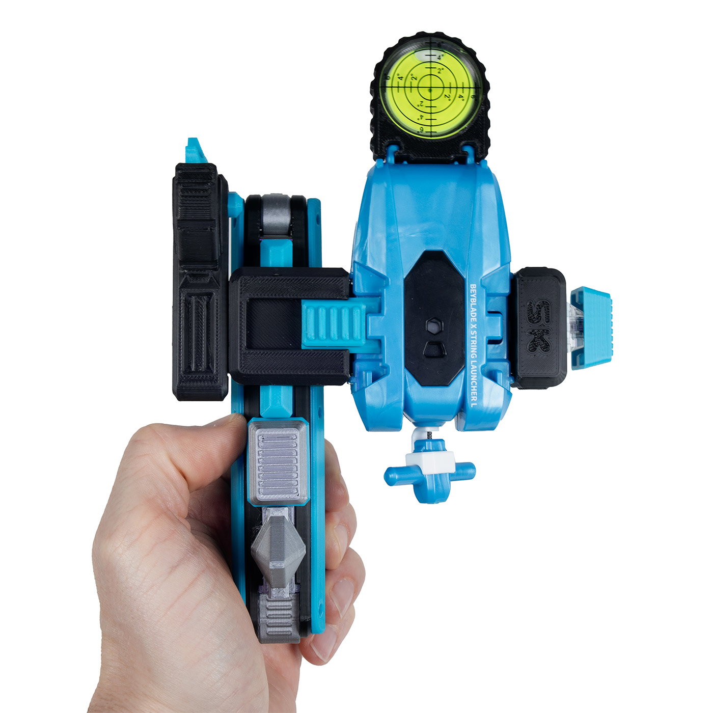 Beyblade Expansion in hand: a cyan Beyblade X string launcher mounted on a kARTIFACT