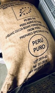 Prall gefüllter Jutesack mit EU-Bio-Siegel, der Aufschrift „Organic Cocoa Beans Forastero … from Peru“, einem großen Kreis „Perú Puro“ und Chargenangaben