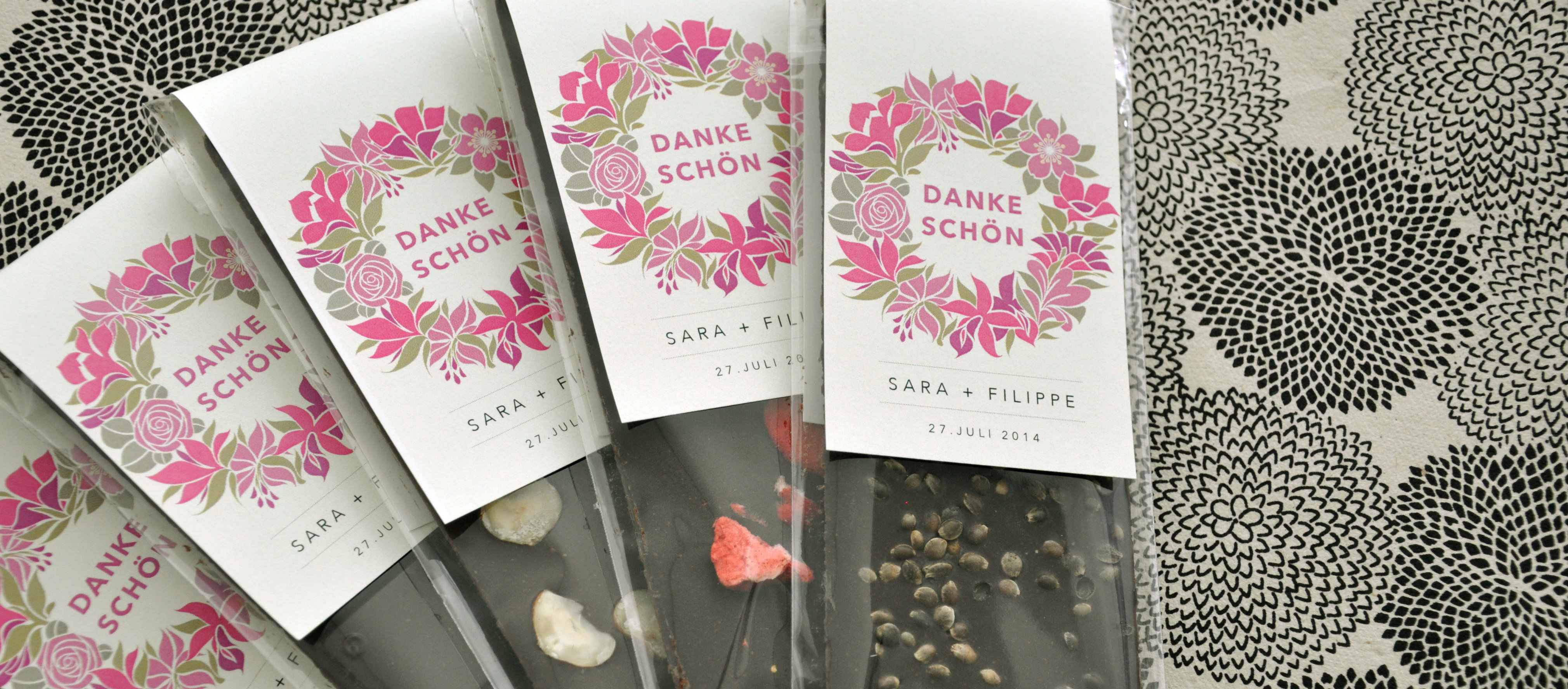 Selbstgemachte Schokoladentafeln mit Toppings, einzeln verpackt mit Dankeschön-Karten als Gastgeschenk