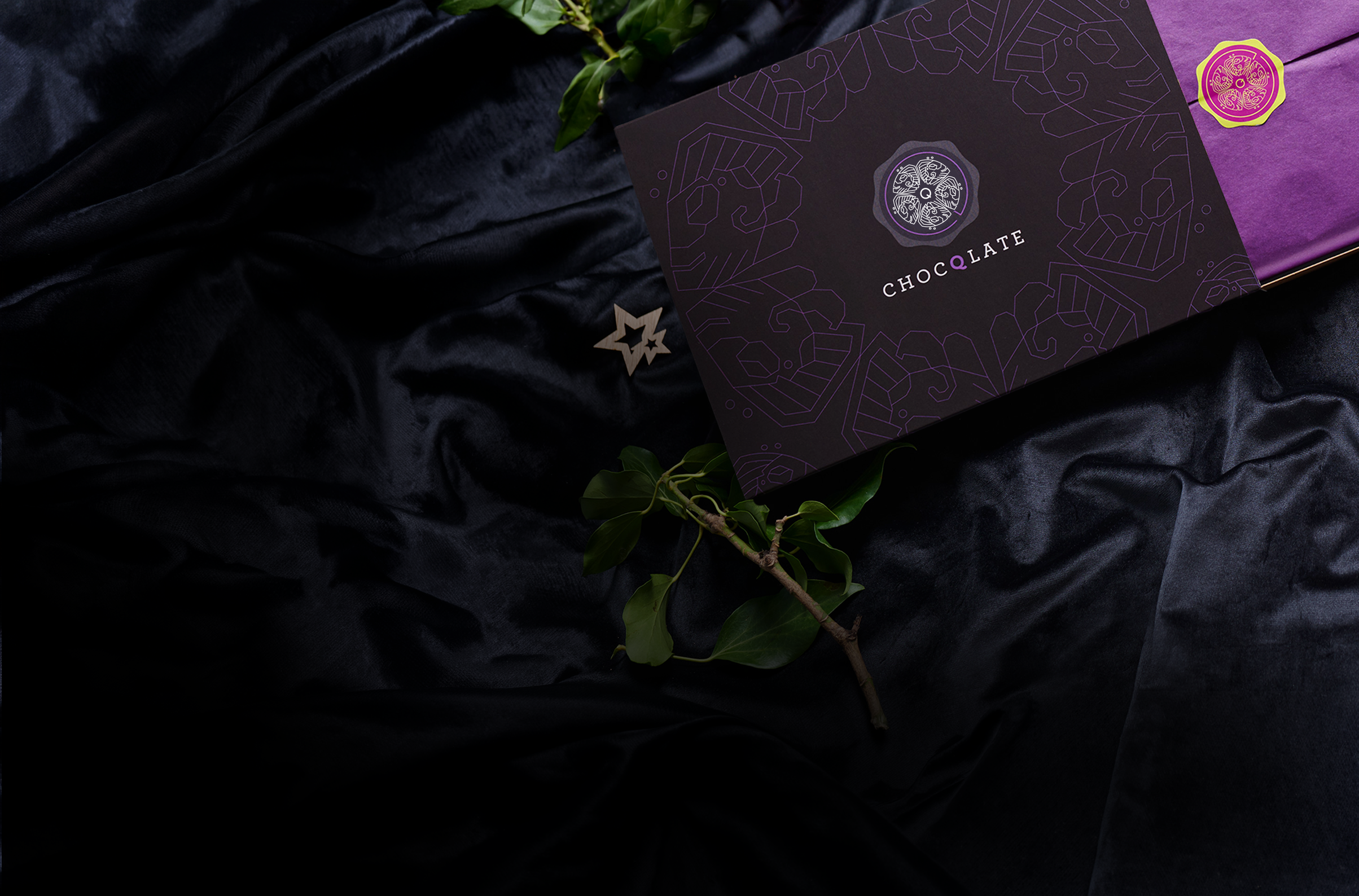 CHOCQLATE Geschenkbox auf dunklem Samt mit Efeuzweig