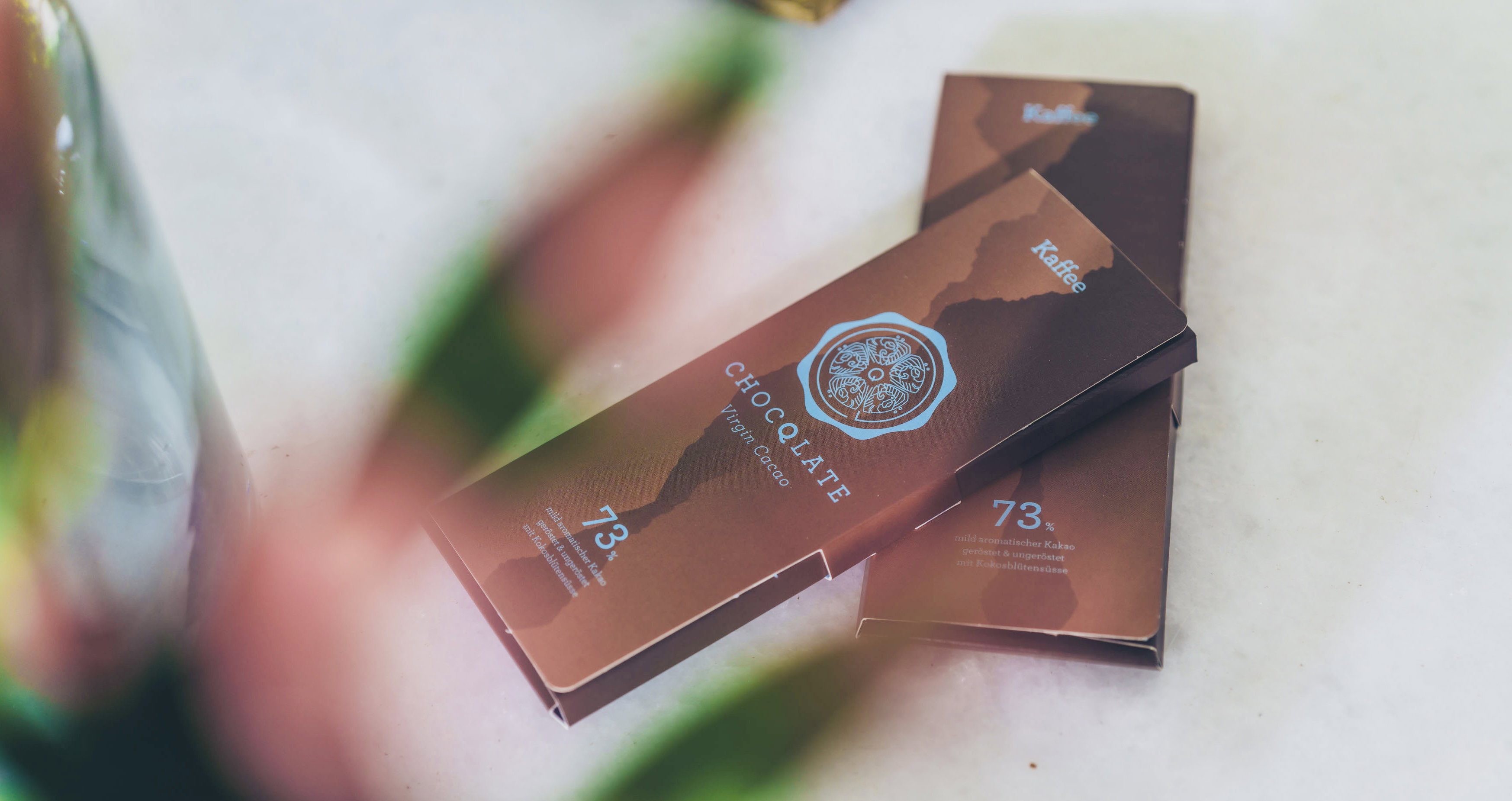 Zwei Tafeln CHOCQLATE Kaffee-Schokolade 73 % auf hellem Marmor