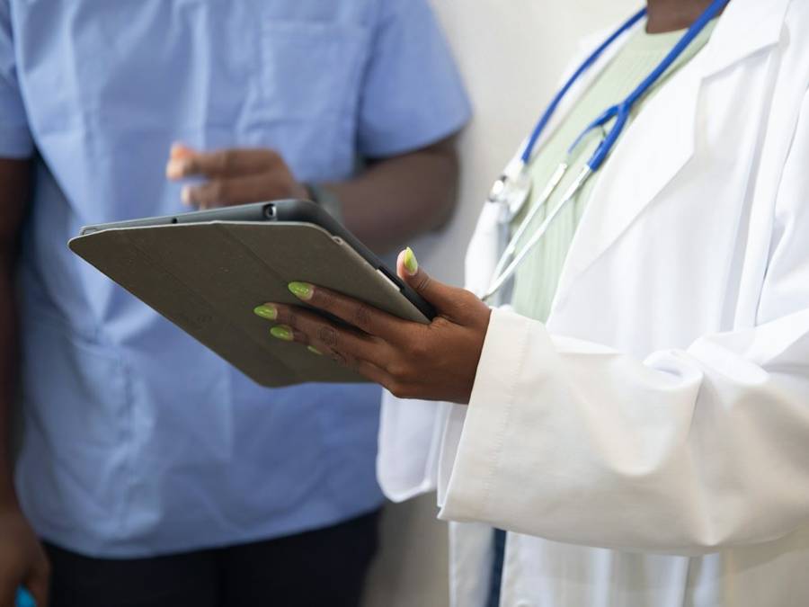 Doctor reviewing notes on a tablet with a colleague