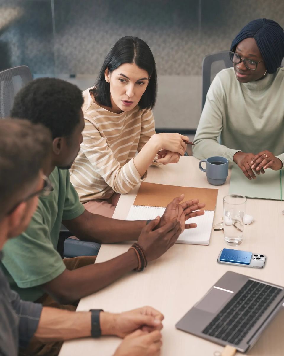 A team talking around a meeting table, with Pocket on the table recording