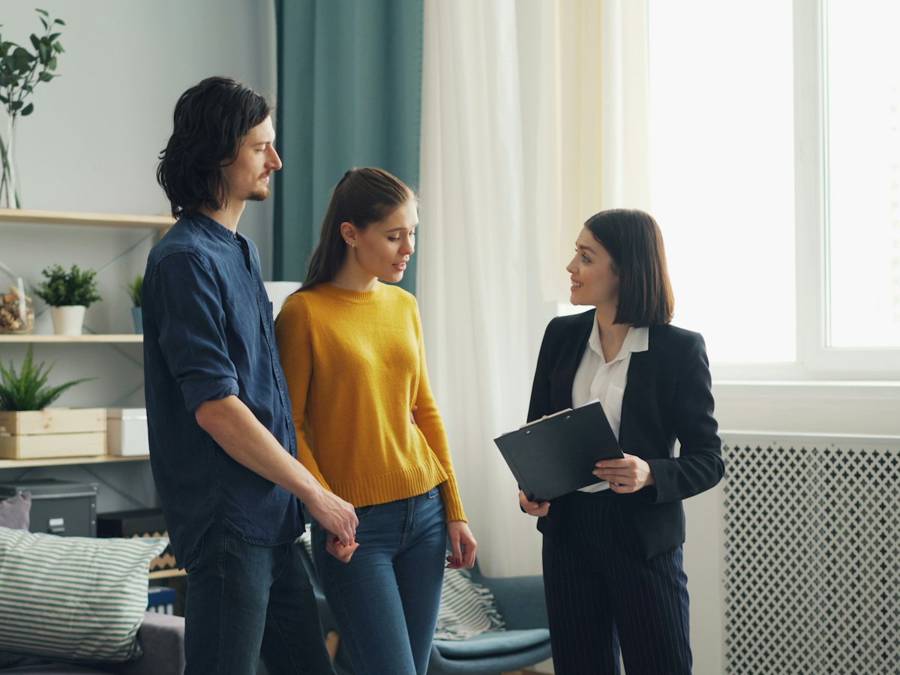 Estate agent showing a couple around a home