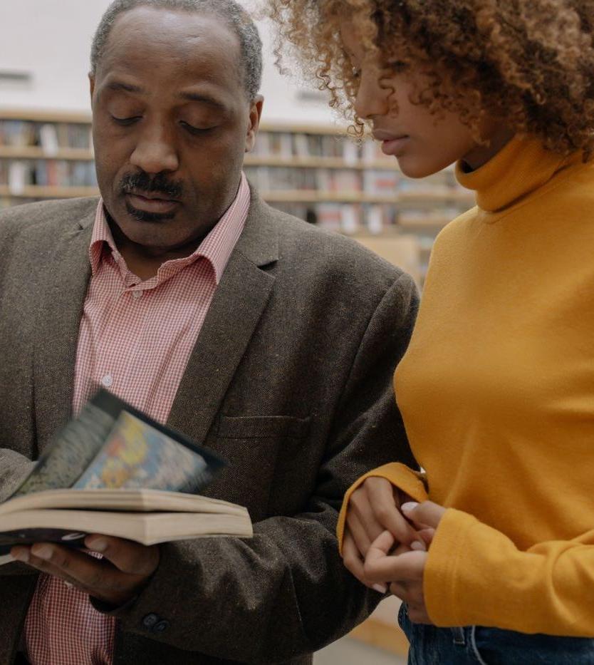 A lecturer and a student going over a book in a university library