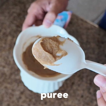 Thick, creamy wildwhip purée on a spoon, ready to spoon feed a cat