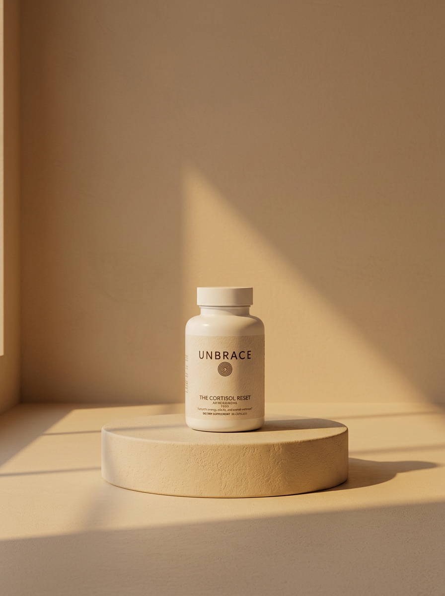 The Cortisol Drop in a matte amber glass jar on a beige plaster pedestal