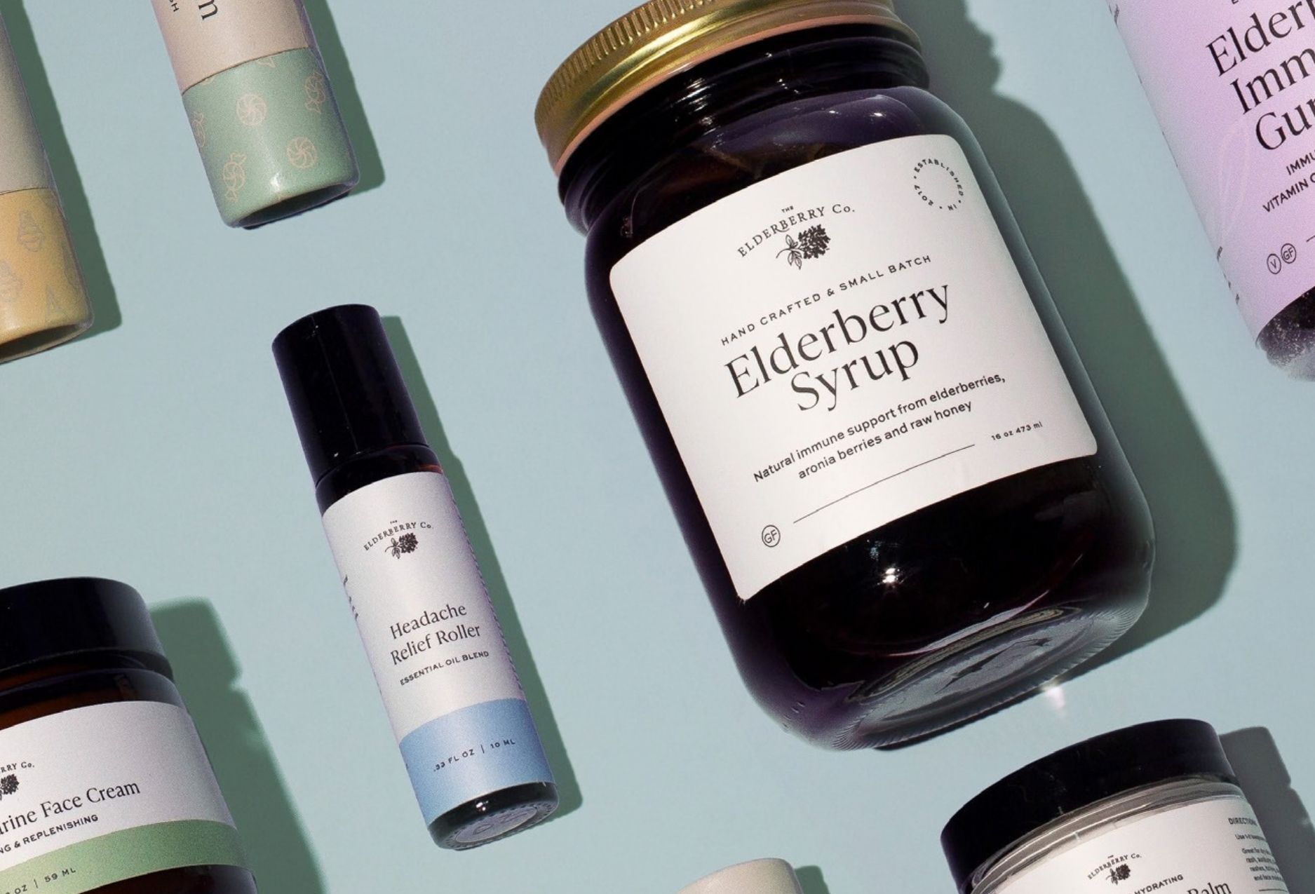 The Elderberry Co. gummy bottles — collagen, sleep, immunity, lion's mane and multivitamin — surrounded by fresh fruit