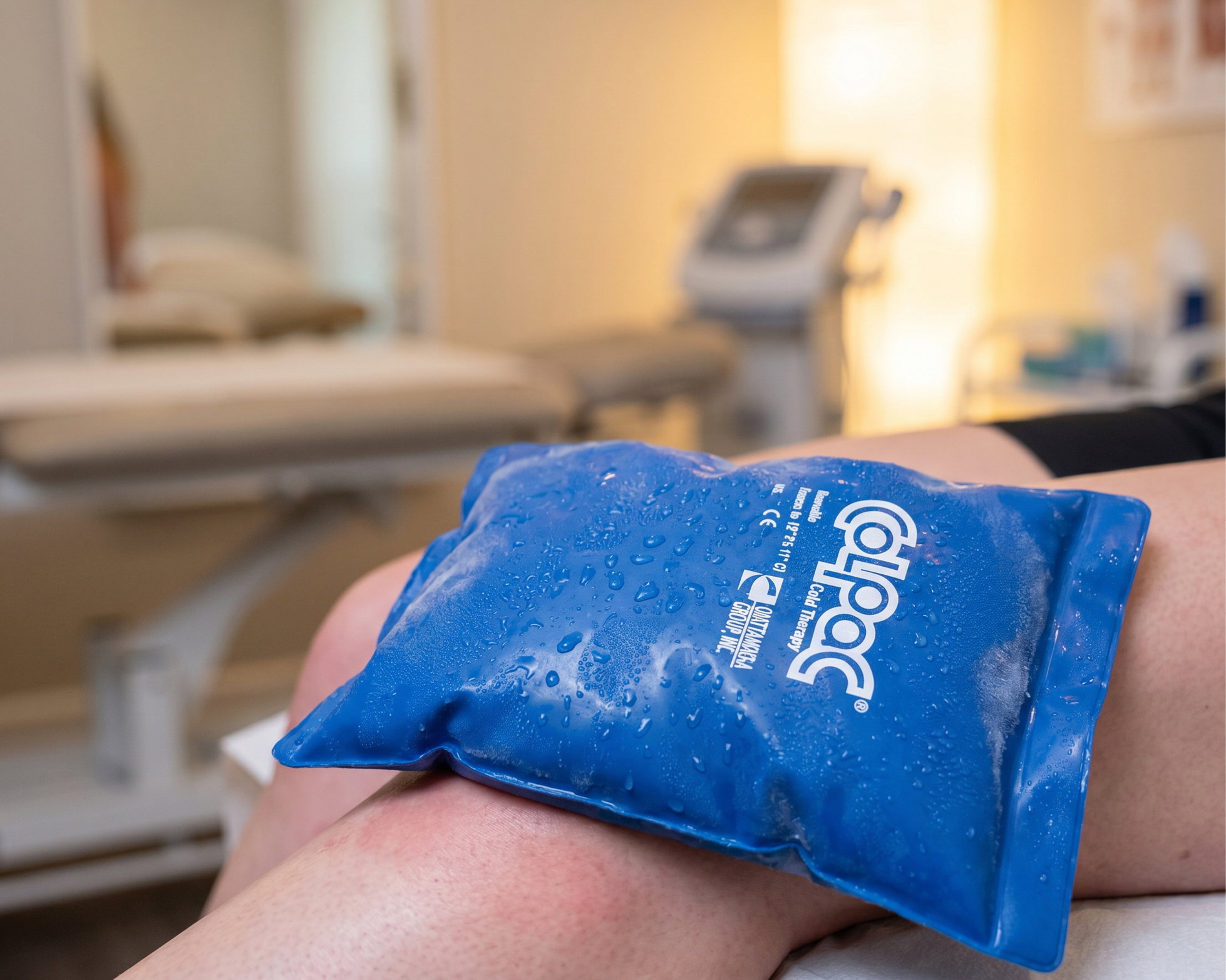 Compresse froide ColPaC bleue « Chattanooga » posée sur le genou d'un patient dans un cabinet de kinésithérapie