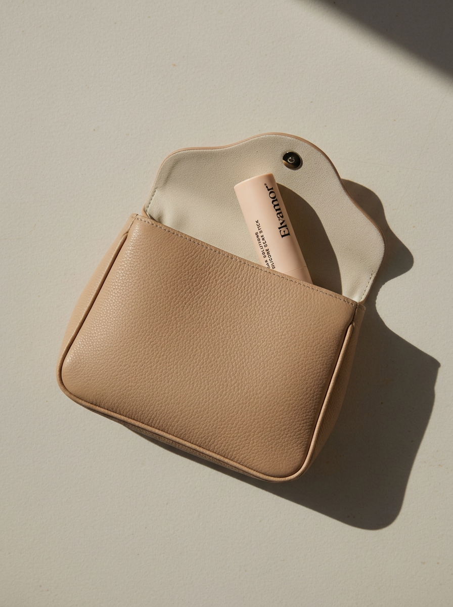 Beige leather purse partially open with a pink skincare bottle inside on a white surface