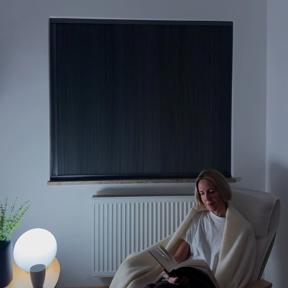 Woman resting in a dark room with Guard blinds fully closed