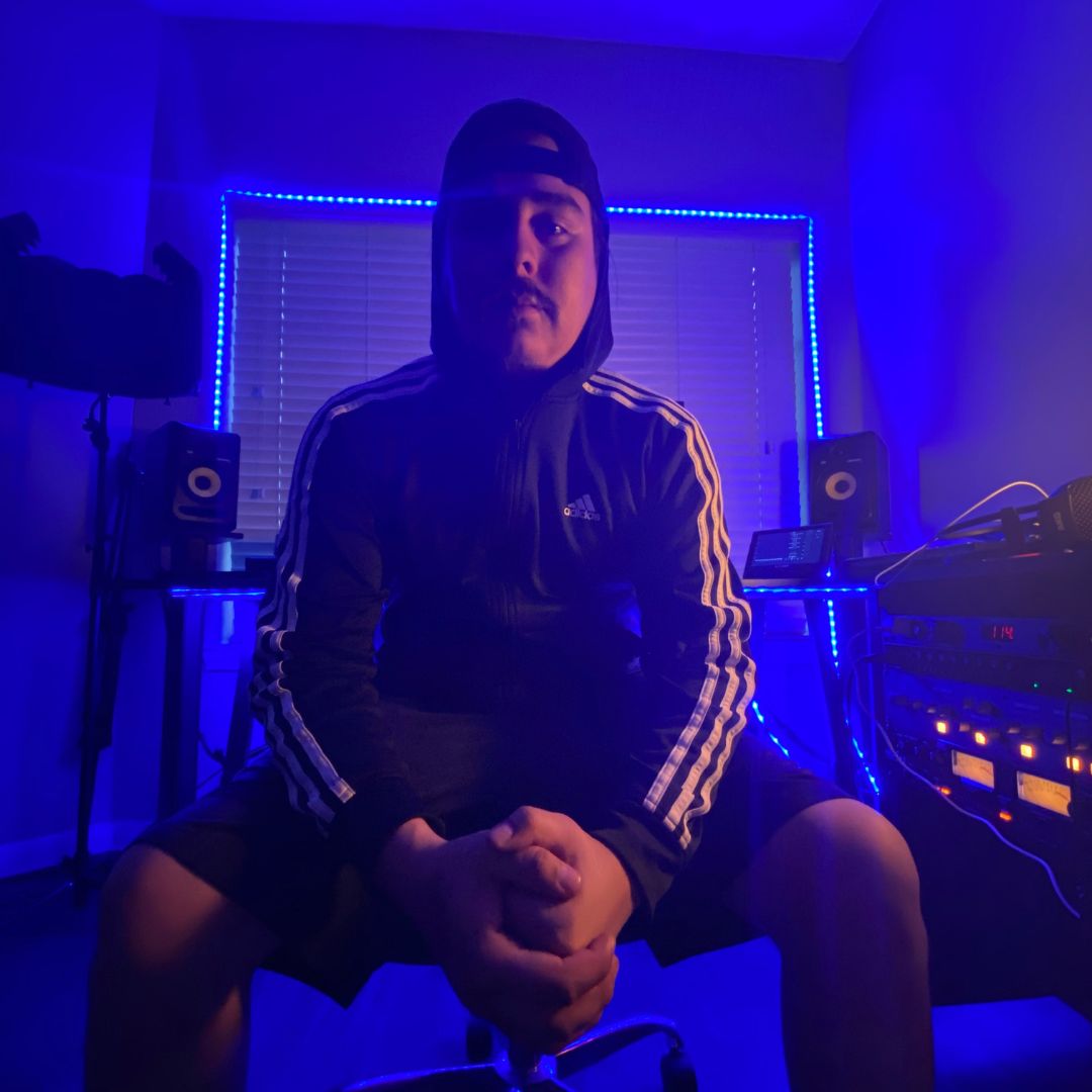 ICECOLDGOON in his studio, seated between monitors and outboard gear