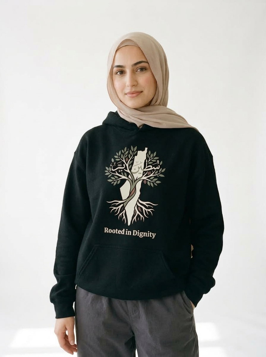 Woman wearing the forest green Rooted in Dignity tee, a Palestine solidarity shirt with olive tree and Arabic script design