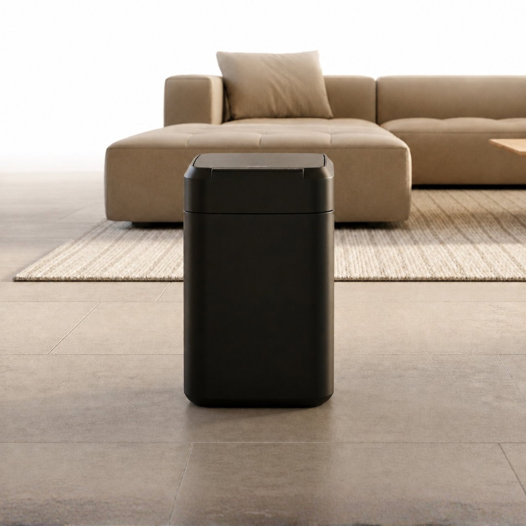 Hand dropping kitchen scraps into an open smart trash can