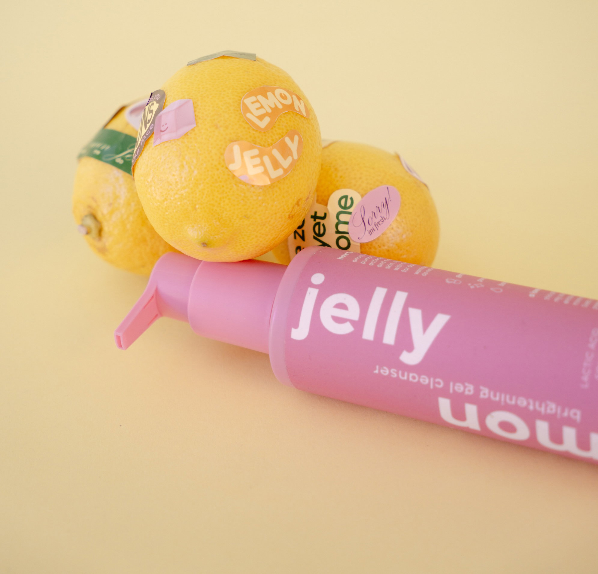 Lemon Jelly cleanser bottle with fresh citrus on a glossy surface