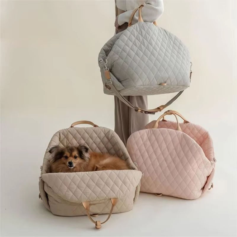 Porter carriers in grey, beige and pink, with a small fluffy dog resting in the beige one
