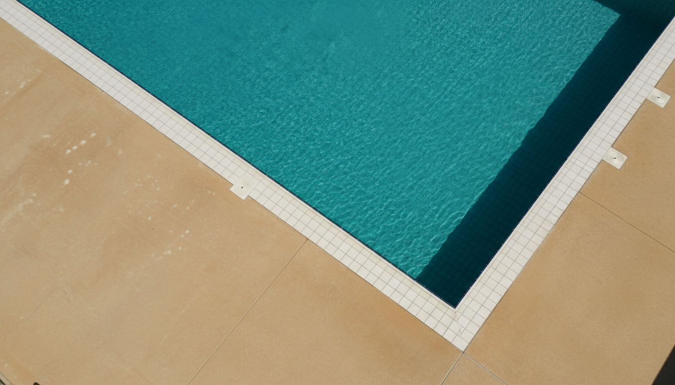 Sunlit pool edge with rippling turquoise water