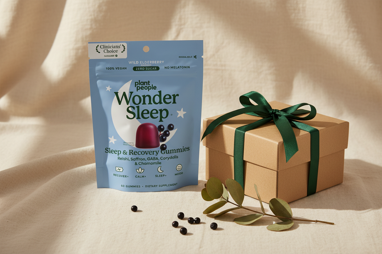 Wonder Sleep pouch beside a kraft gift box tied with green ribbon and eucalyptus on cream linen