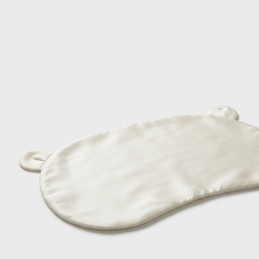 Close-up of the ivory Mulberry silk head sheet with two little ears on a light grey background