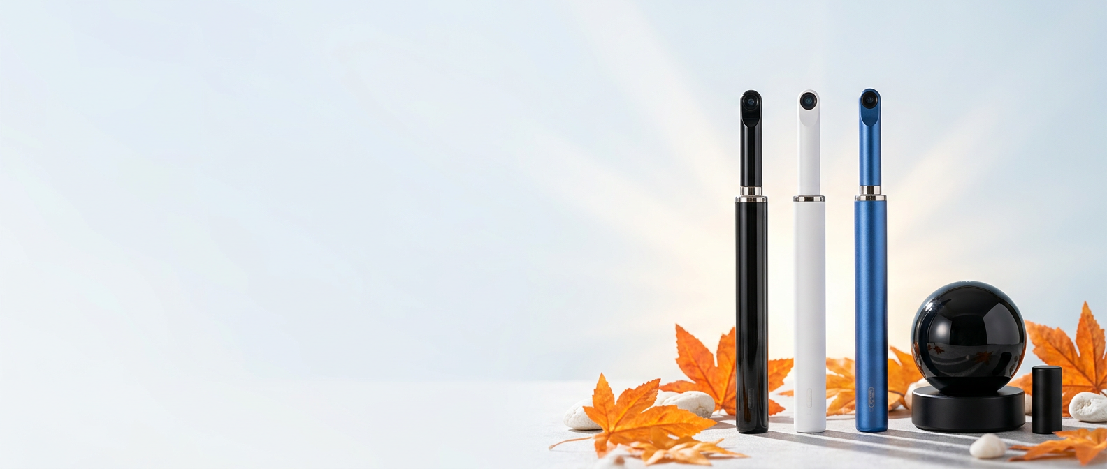 Bebird ear cleaners in black, white and blue beside a black smart device, surrounded by autumn maple leaves