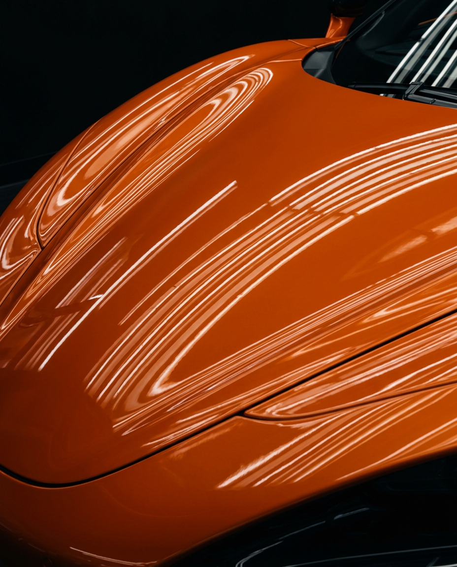 Spiegelnde Lichtreflexionen auf der orangefarbenen Motorhaube eines McLaren