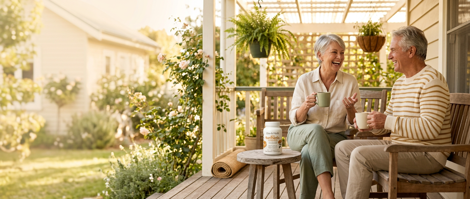 Couple in their sixties laughing over morning coffee on their porch, a bottle of Elm & Herb turmeric on the table
