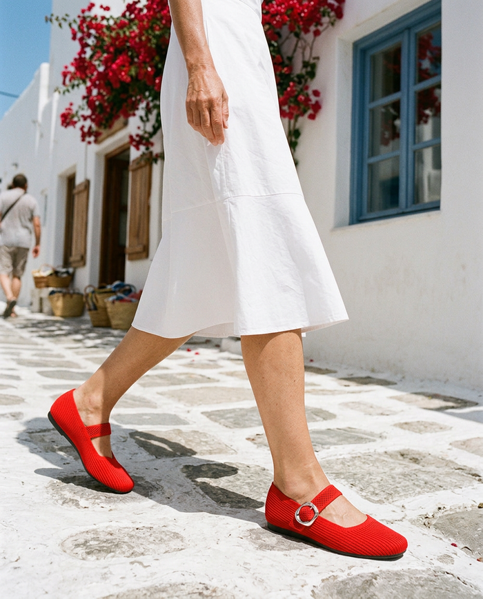 Walking a sunny whitewashed street in the Scarlet Red Mary Jane comfort flats